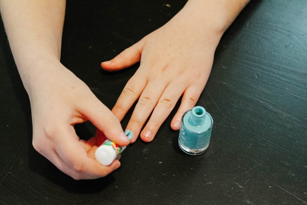 Suncoatgirl nail polish being painted by a childs hand