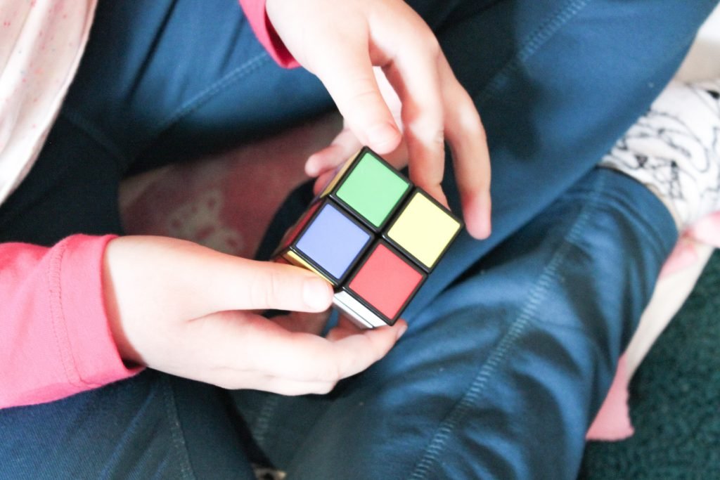 Child's hands trying to solve Rubik's Cube