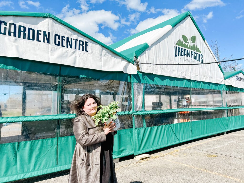 Eschelle from Mumfection holding Hosta plant outside of Urban Roots Garden Centre